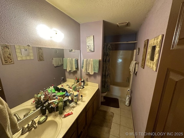 full bathroom featuring double vanity, a sink, a textured ceiling, and tile patterned floors