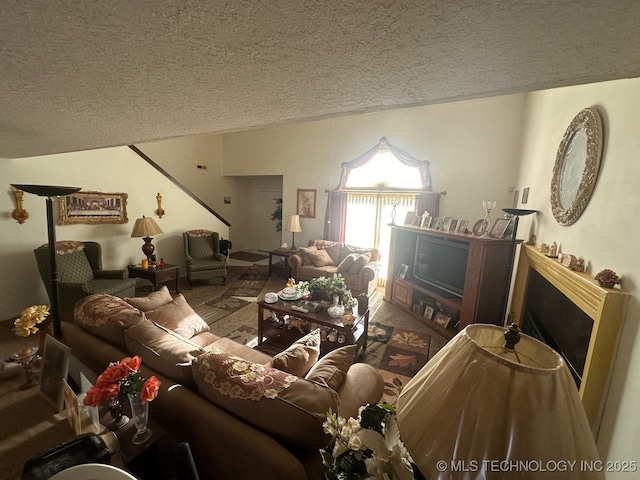 carpeted living room with a textured ceiling, a fireplace, and lofted ceiling