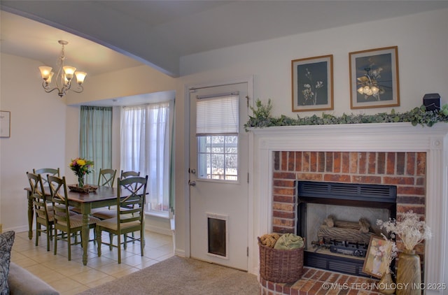 dining space with a notable chandelier, a fireplace, light tile patterned floors, light colored carpet, and baseboards