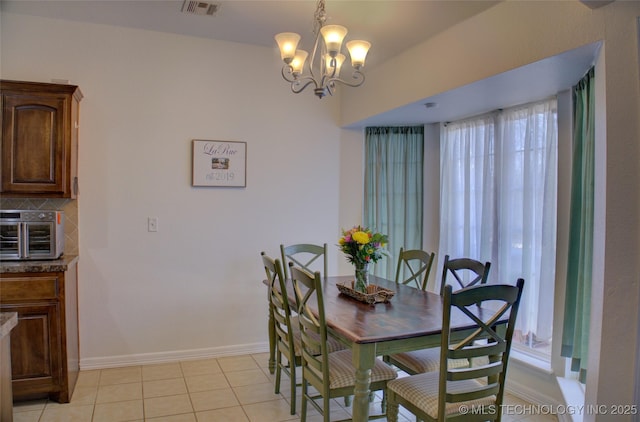 dining area with a toaster, light tile patterned floors, visible vents, an inviting chandelier, and baseboards