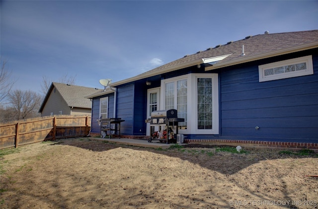 back of house with a patio and fence