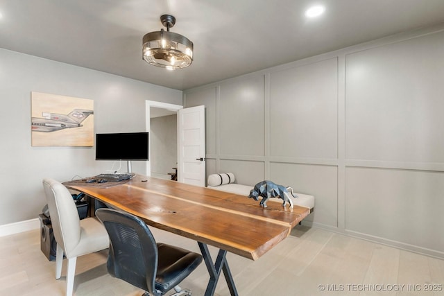 office area featuring light wood-type flooring and a decorative wall