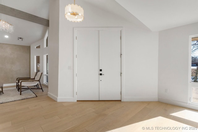 foyer entrance with a chandelier, high vaulted ceiling, visible vents, baseboards, and light wood-type flooring