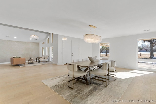 dining space with a chandelier, visible vents, light wood-style flooring, and baseboards