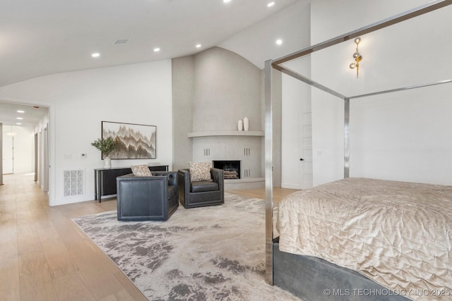 bedroom featuring recessed lighting, visible vents, a fireplace, and light wood finished floors