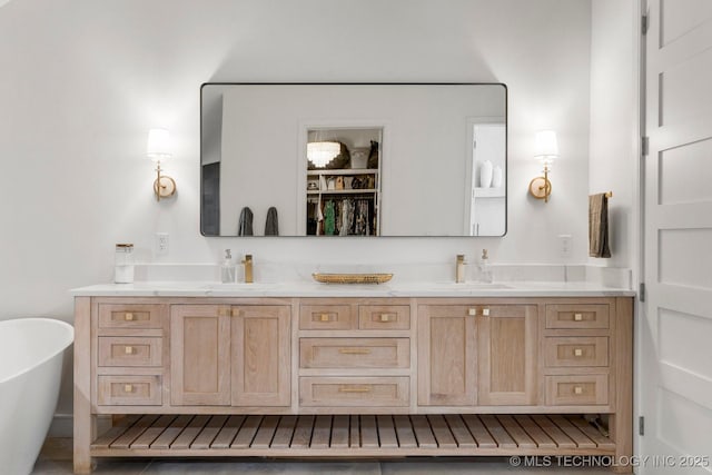 full bath with a freestanding tub, a sink, and double vanity