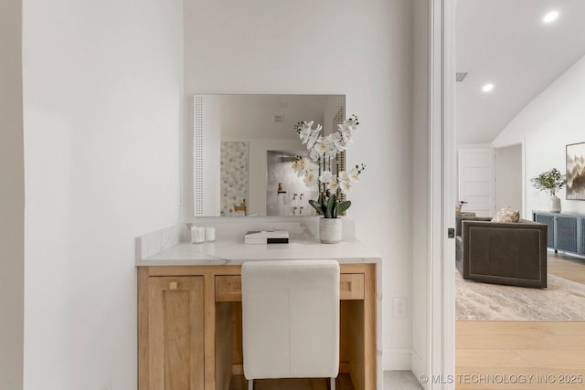 bathroom featuring lofted ceiling, wood finished floors, and recessed lighting