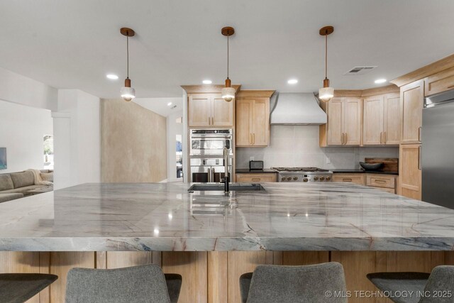 kitchen featuring visible vents, light brown cabinetry, premium range hood, and appliances with stainless steel finishes