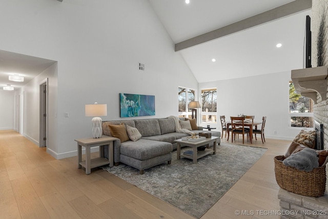 living area with a stone fireplace, visible vents, light wood-style flooring, and baseboards