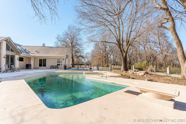 outdoor pool featuring fence and a patio