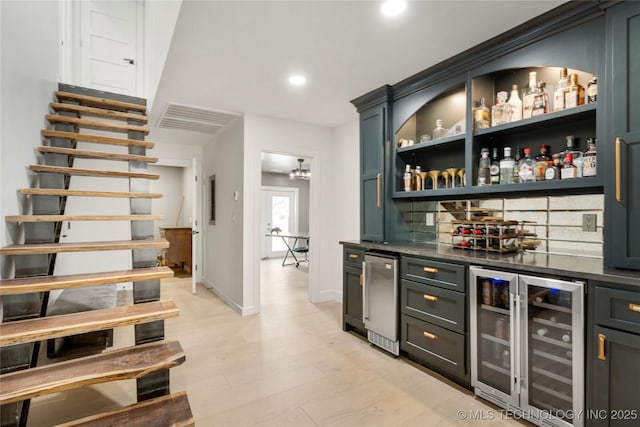 bar featuring wine cooler, visible vents, light wood-style floors, decorative backsplash, and a bar