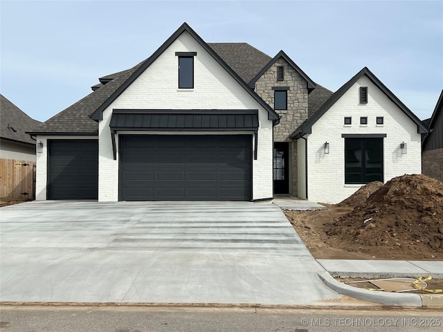 view of front facade featuring driveway, brick siding, and roof with shingles