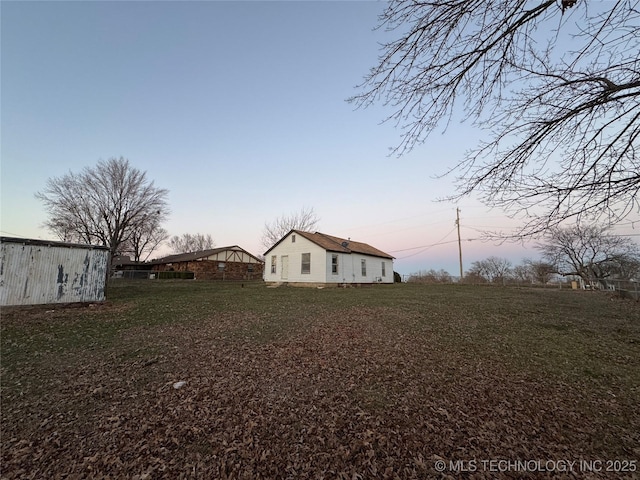 yard at dusk featuring a pole building and an outdoor structure