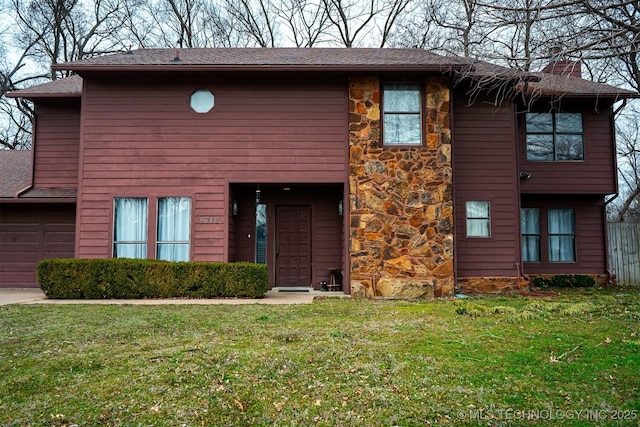 view of front of property featuring a garage, fence, stone siding, a chimney, and a front yard