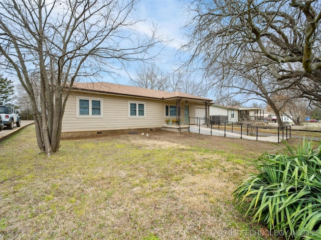 rear view of property featuring crawl space, fence, and a yard