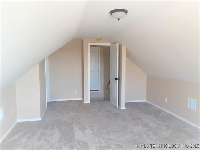 bonus room featuring lofted ceiling, carpet, visible vents, and baseboards