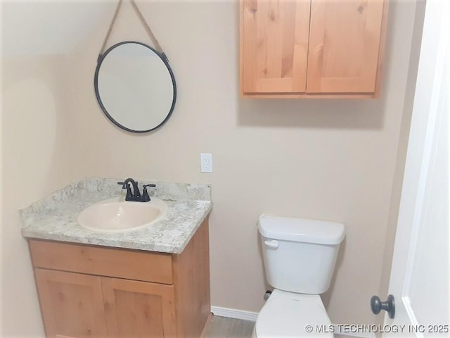 half bathroom featuring toilet and vanity