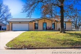 view of front of house with a garage, driveway, and a front lawn