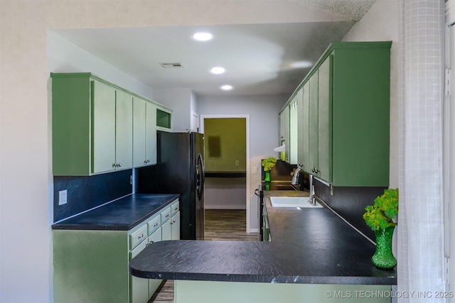 kitchen with dark countertops, visible vents, and green cabinetry