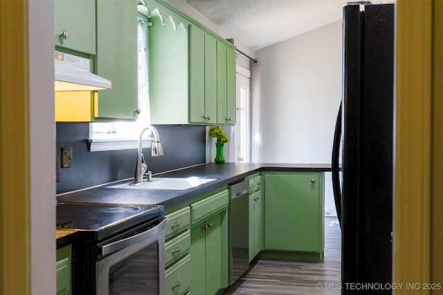 kitchen featuring a sink, range hood, appliances with stainless steel finishes, and green cabinetry