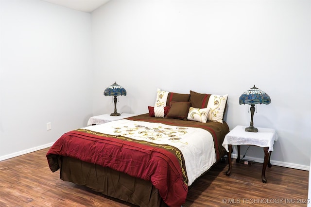 bedroom featuring baseboards and wood finished floors