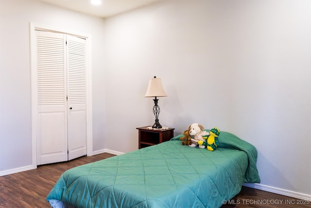 bedroom featuring a closet, baseboards, and wood finished floors