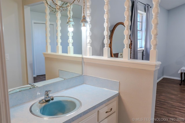 bathroom featuring vanity, baseboards, and wood finished floors