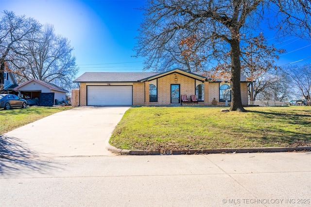 mid-century inspired home with a garage, driveway, brick siding, and a front lawn