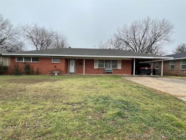 single story home with driveway, brick siding, a carport, and a front yard