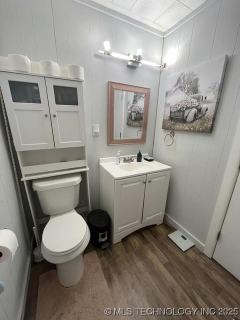 bathroom with toilet, wood finished floors, and vanity