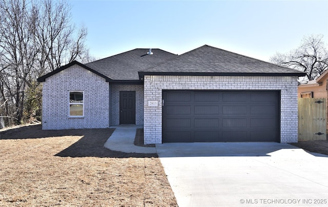 ranch-style home featuring a garage, driveway, a shingled roof, and brick siding