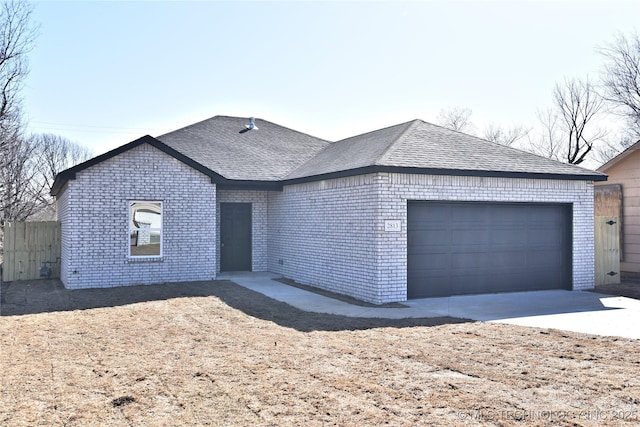 ranch-style house featuring a garage, brick siding, a shingled roof, and fence