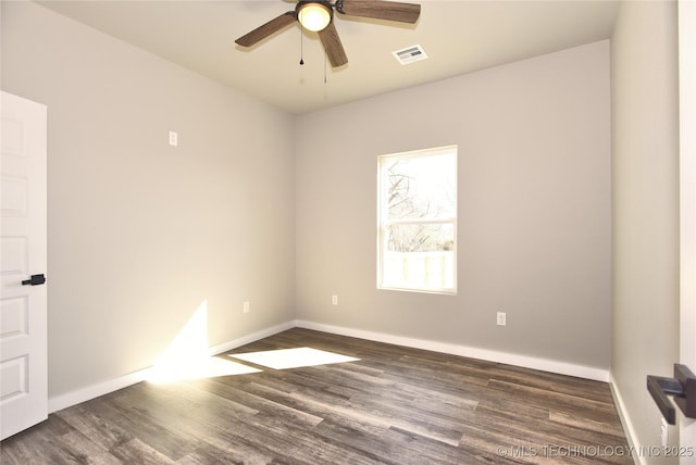 empty room with a ceiling fan, wood finished floors, visible vents, and baseboards