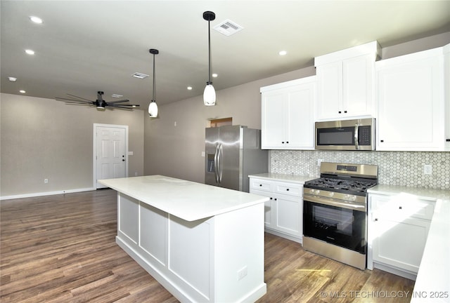 kitchen featuring visible vents, backsplash, appliances with stainless steel finishes, white cabinetry, and wood finished floors