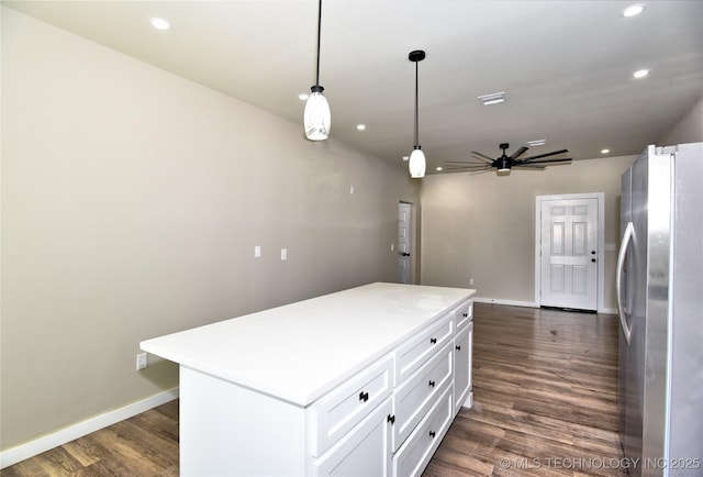 kitchen featuring white cabinets, a kitchen island, dark wood-type flooring, freestanding refrigerator, and recessed lighting