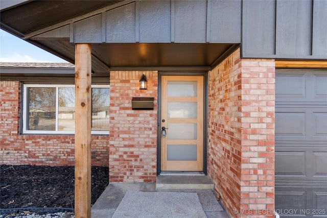 property entrance featuring brick siding and an attached garage