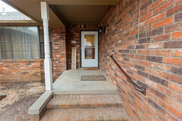 property entrance featuring brick siding