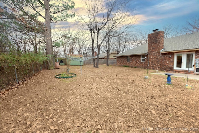 view of yard featuring a fenced backyard and french doors