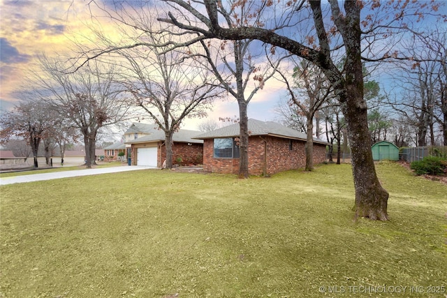 view of front of property featuring a garage, brick siding, fence, concrete driveway, and a front yard