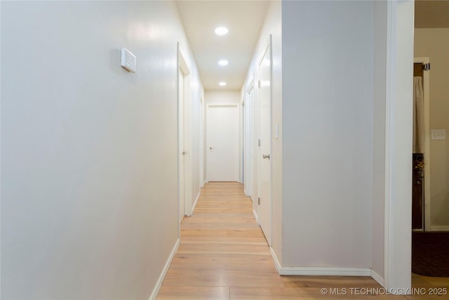 hall with baseboards, recessed lighting, and light wood-style floors