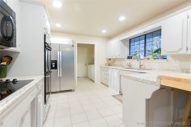 kitchen with light tile patterned floors, recessed lighting, a sink, white cabinets, and black appliances