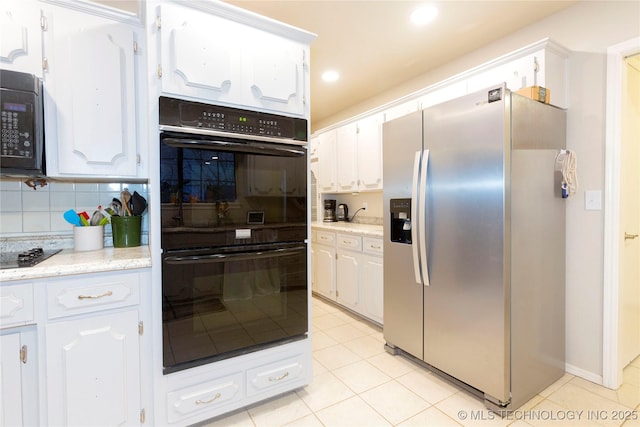 kitchen with black appliances, tasteful backsplash, and white cabinets