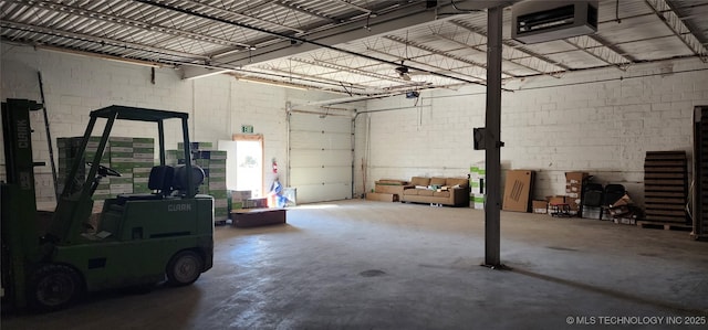 garage with concrete block wall and a garage door opener