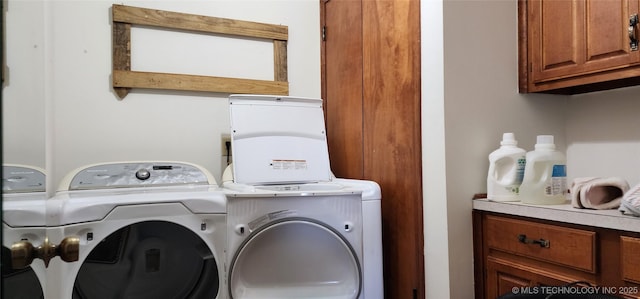 clothes washing area with cabinet space and separate washer and dryer