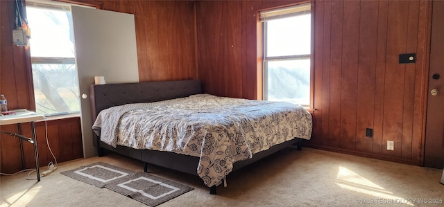 bedroom with carpet floors and wood walls