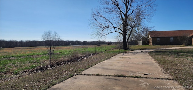 view of yard featuring fence and a rural view