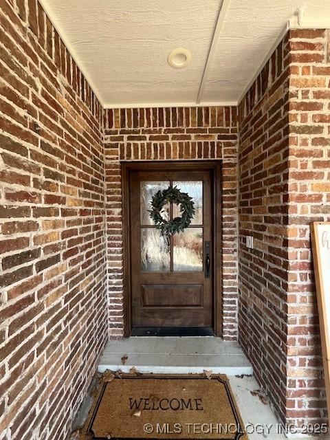 view of exterior entry with brick siding