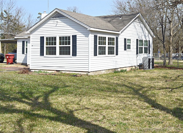 view of home's exterior featuring central AC unit, fence, and a lawn