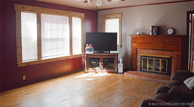 living room with a ceiling fan, wood finished floors, and a glass covered fireplace