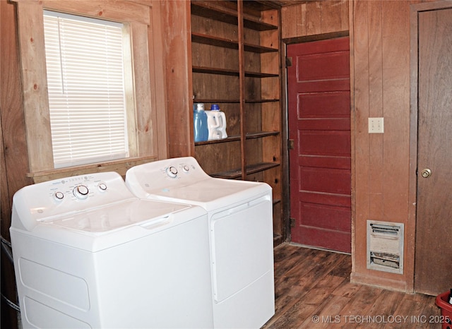 laundry room featuring dark wood-type flooring, washing machine and dryer, laundry area, and wood walls